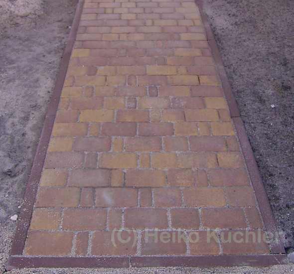 Betonpflasterweg mit Rasenkanten